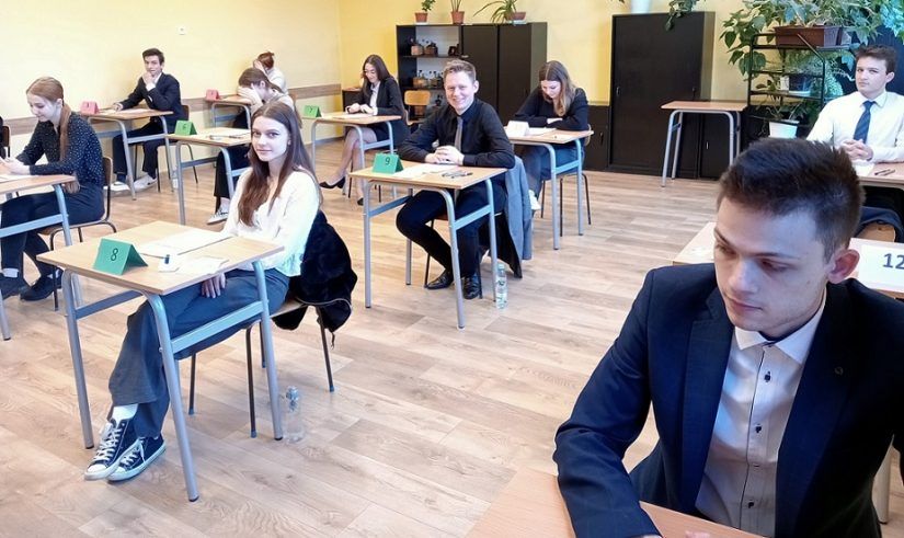 Uczniowie tuż przed ropoczęciem egzaminu siedzą na wylosowanych miejscach w sali egzaminacyjnej.