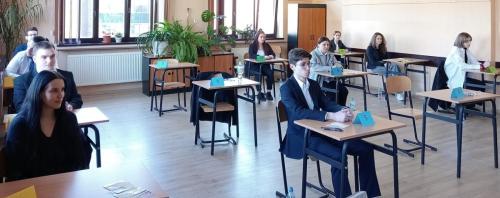 Uczniowie ZSCH tuż przed rozpoczęciem matury, siedzą przy wylosowanych stolikach. Zdjęcie 2