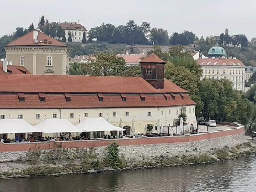 Widok na zabytkowe praskie budynki położone nad Dunajem.