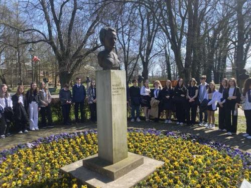 Popiersie Marii Skłodowskiej-Curie w Parku Jordana. W tle uczniowie klas pierwszych.